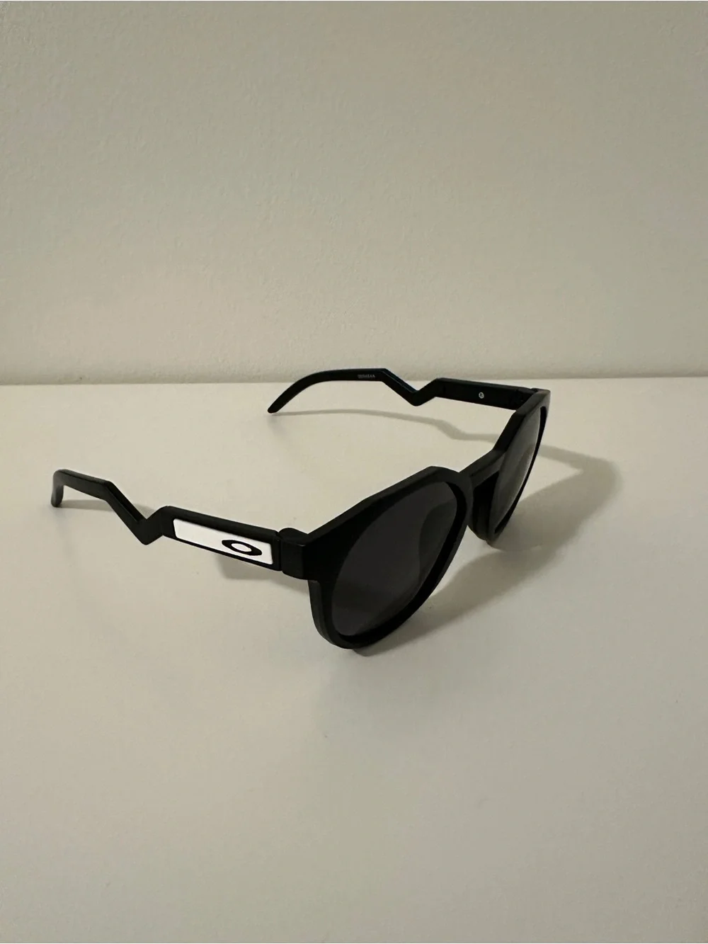 Oakley Black Round Sunglasses with Zigzag Temples and White Logo Accents